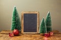 Christmas holiday mock up with chalkboard and pine tree on wooden table