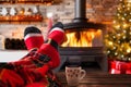 Christmas holiday mood relaxing in front of cozy fireplace and enjoying cup of hot chocolate Royalty Free Stock Photo