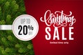 Christmas holiday sale 20 percent off with paper sticker on red background with fir tree branches. Limited time only Royalty Free Stock Photo