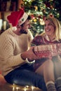 Christmas holiday - Smiling couple with gift enjoying on Christmas eve.