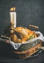 Christmas holiday table set with roasted whole chicken and candles Royalty Free Stock Photo