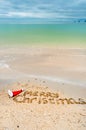 Christmas holiday tropical vacation concept, Merry Christmas written on tropical beach sand and sea background