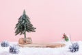 Christmas holiday wooden podium or stand in snow with Christmas tree and candle