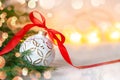 Christmas holidays composition with white ball and red ribbon on light background with copy space Royalty Free Stock Photo