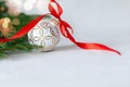 Christmas holidays composition with white ball and red ribbon on light background with copy space Royalty Free Stock Photo