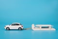 Christmas holidays concept. Close up photo of toy mini car carrying white wooden sledge isolated on blue background Royalty Free Stock Photo