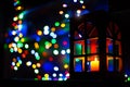 Christmas holidays festive lights inside home in dark room with foreground lantern with candle and background blurred bokeh Royalty Free Stock Photo