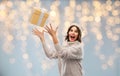 Young woman in winter hat catching gift box Royalty Free Stock Photo