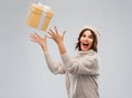 Young woman in winter hat catching gift box Royalty Free Stock Photo