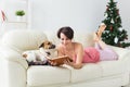 Christmas, holidays and people concept - happy young woman reading book at home. Royalty Free Stock Photo