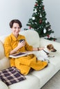 Christmas, holidays and people concept - happy young woman reading book at home. Royalty Free Stock Photo