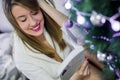 Christmas, holidays and people concept - happy young woman reading book at home. Royalty Free Stock Photo