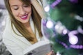 Christmas, holidays and people concept - happy young woman reading book at home. Royalty Free Stock Photo