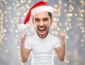 Screaming man in santa hat over lights Royalty Free Stock Photo