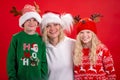 Christmas Holidays Portrait happy family of three In Santa hats mother and kids standing and Smiling on red studio Royalty Free Stock Photo