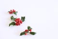 Christmas holly with red berries. Traditional festive decoration. Holly branch with red berries on white table Royalty Free Stock Photo