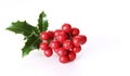 Christmas holly with red berries. Traditional festive decoration. Holly branch with red berries on white table Royalty Free Stock Photo