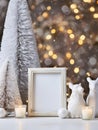 Christmas home decor with candles, figures of bears, empty picture frame and Christmas ornaments on table Royalty Free Stock Photo