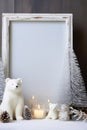 Christmas home decor with candles, figures of bears, empty picture frame and Christmas ornaments on table Royalty Free Stock Photo