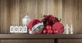 Christmas home decorations and metal calendar for year 2022 against wooden wall. Royalty Free Stock Photo