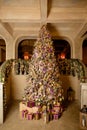 Christmas home interior with tree and stairs. Traditional living room in country house decorated with lights and candles Royalty Free Stock Photo