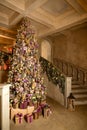 Christmas home interior with tree and stairs. Traditional living room in country house decorated with lights and candles Royalty Free Stock Photo