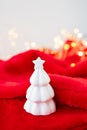 Christmas home interior with a white ceramic Christmas tree on a red blanket. Christmas and New Year concept. Vertical photo Royalty Free Stock Photo