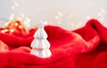 Christmas home interior with a white ceramic Christmas tree on a red plaid and bokeh with a garland in the background. Christmas Royalty Free Stock Photo