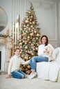 Christmas at home. Son and mom and dog under tree. A boy and woman are playing Royalty Free Stock Photo