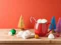 Christmas Hot Chocolate Cup With Marshmallow And Christmas Decorations On Wooden Table Over Red Background