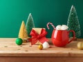 Christmas Hot Chocolate Cup With Marshmallow, Gift Box And Decorations On Wooden Table Over Green Background. Festive Greeting