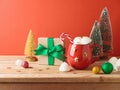 Christmas Hot Chocolate Cup With Marshmallow, Gift Box And Decorations On Wooden Table Over Red Background