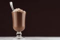 Christmas hot chocolate in irish coffee glass with marshmallows and silver spoon on dark brown and white background. Royalty Free Stock Photo