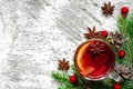 Christmas hot mulled wine with cinnamon, anise and fir tree branches on white wooden background.