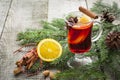 Christmas hot mulled wine with cinnamon, orange and christmas tree on board. Close up. Royalty Free Stock Photo