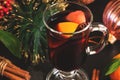 Christmas hot mulled wine in a glass mug with orange spices and fruit close-up. Selective focus