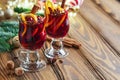 Christmas hot mulled wine. Glasses of mulled wine with aromatic spices cinnamon, anise, sugar and fir tree branches with bokeh and Royalty Free Stock Photo