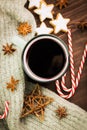 Christmas hot steaming cup of glint wine with spices, anise, cookies in a shape of star, red candies, pepper and gray scarf on