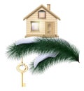 Christmas house with golden key on a pine branch with snow Real Estate as a gift for the new year