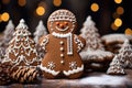 Christmas house, Christmas tree and gingerbread snowman on a background of festive golden bokeh. ÃÂ¡hristmas baking, sweets. Hand Royalty Free Stock Photo