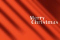 Red texture wall with Merry Christmas text and moody shadows. Royalty Free Stock Photo