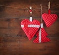 Christmas image of fabric red hearts and tree hanging on rope in front of wooden background. retro filtered Royalty Free Stock Photo