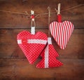 Christmas image of fabric red hearts and tree hanging on rope in front of wooden background. retro filtered Royalty Free Stock Photo
