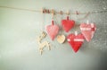 Christmas image of fabric red hearts and tree. wooden reindeer and garland lights, hanging on rope Royalty Free Stock Photo