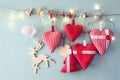 Christmas image of fabric red hearts and tree. wooden reindeer and garland lights, hanging on rope Royalty Free Stock Photo