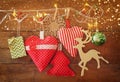 Christmas image of fabric red hearts and tree. wooden reindeer and garland lights, hanging on rope in front of blue wooden backgro Royalty Free Stock Photo