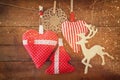 Christmas image of fabric red hearts and tree. wooden reindeer and garland lights, hanging on rope in front of wooden background. Royalty Free Stock Photo