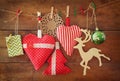 Christmas image of fabric red hearts and tree. wooden reindeer and garland lights, hanging on rope in front of wooden background Royalty Free Stock Photo