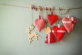 Christmas image of fabric red hearts and tree, wooden reindeer, hanging on rope in front of blue wooden background. retro filtered Royalty Free Stock Photo