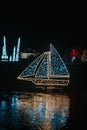 Christmas installations from garlands. Christmas ship made of shining garlands in the dark.Shimmering street scenery